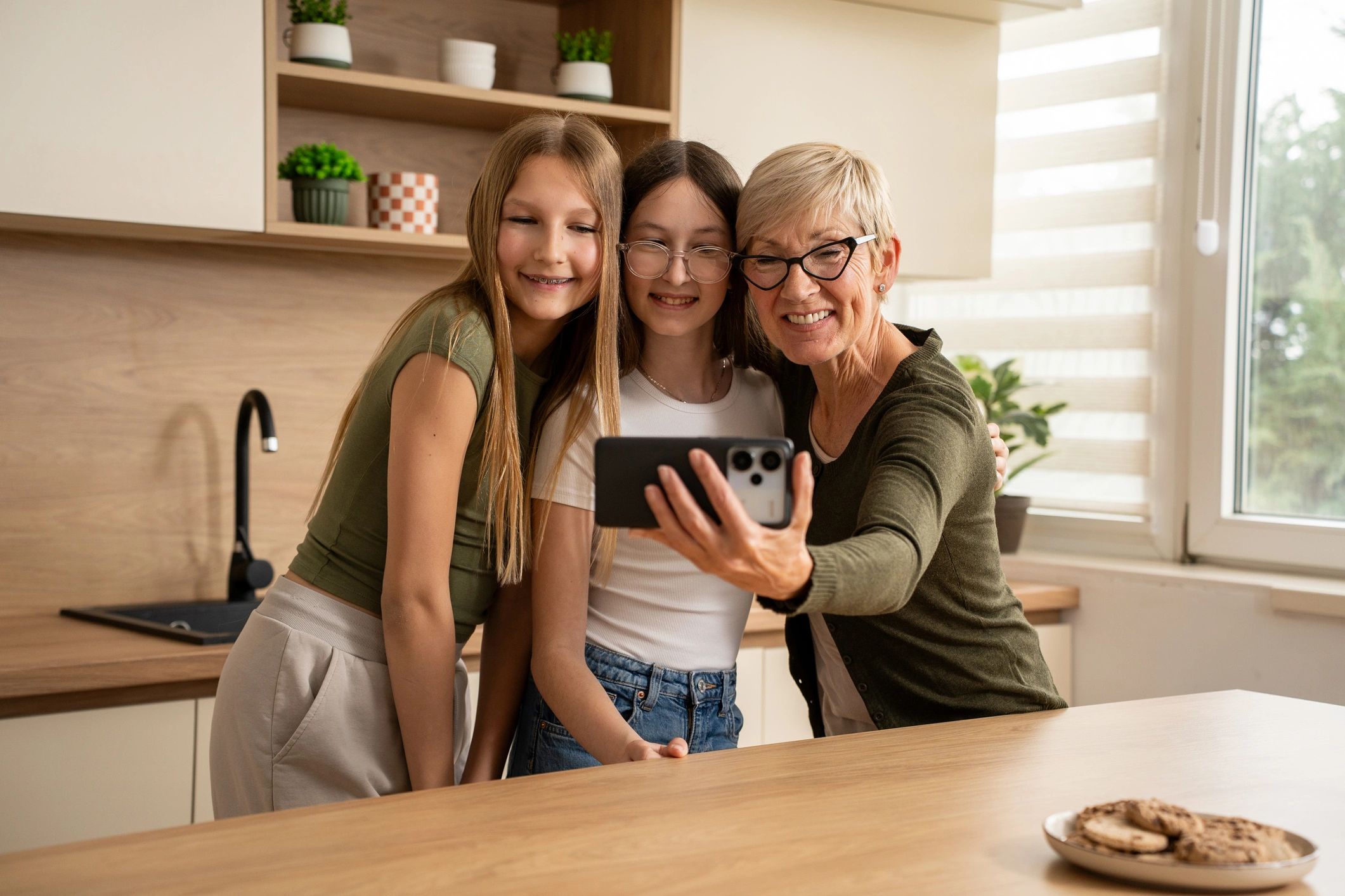 Grandmother taking a selfie with her granddaughters at home
